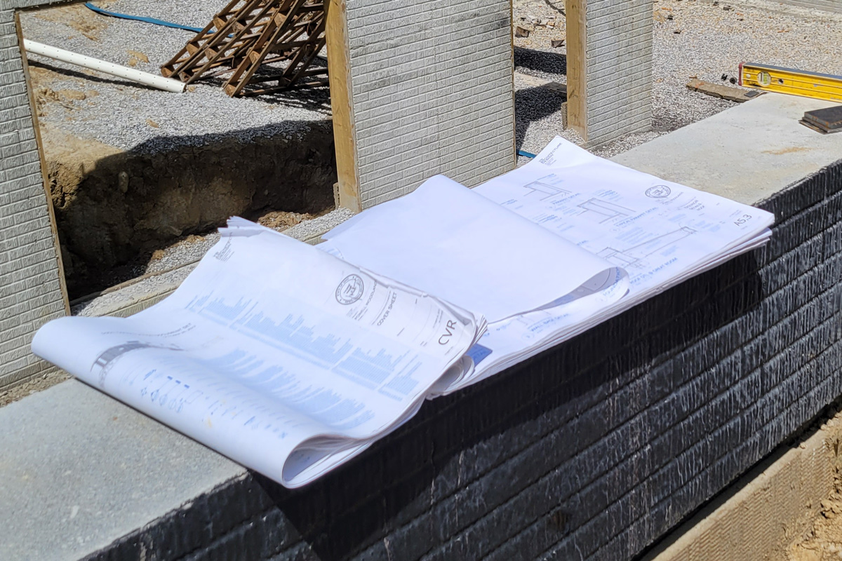 custom home construction drawings a large-format set of architectural drawings on a construction job site
